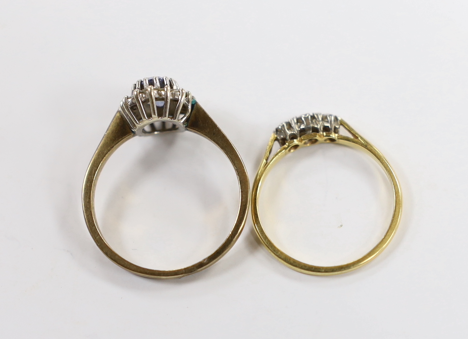 An 18ct, plat and three stone diamond chip set ring, size M and a modern 9ct gold, sapphire and diamond set oval cluster ring.